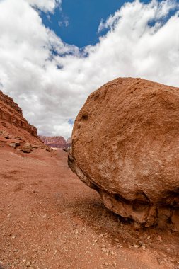Gökyüzünün altında devasa bir kaya kütlesi var. Her nesne dev boyutta. Vermillion uçurum menzili, Page, AZ, ABD.