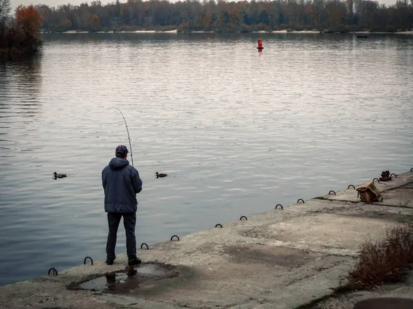 Fisherman on the embankment of the river is fishing