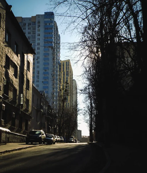 The road is among the tall buildings in the morning city at dawn