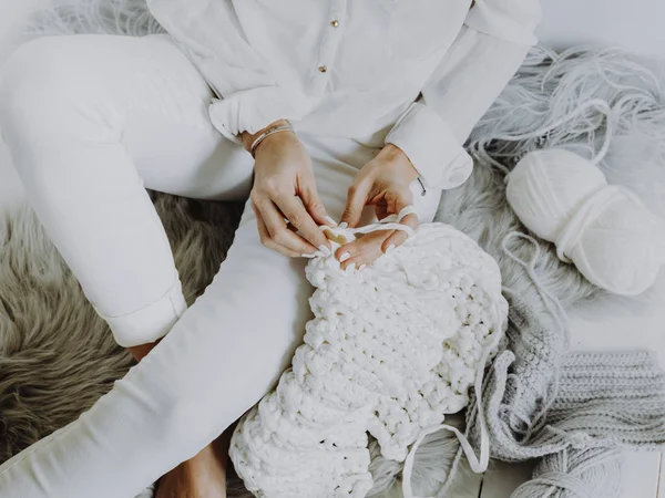 木製の床の上に座って 白いウールでかぎ針編みの女性観をトリミング — ストック写真