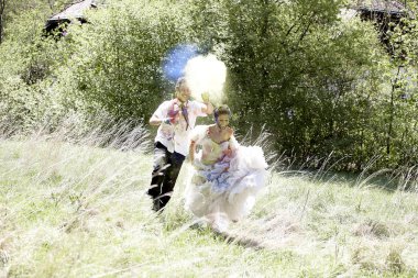 Genç ve güzel gelin ve damat renkli holi tozuyla birlikte vakit geçiriyorlar.