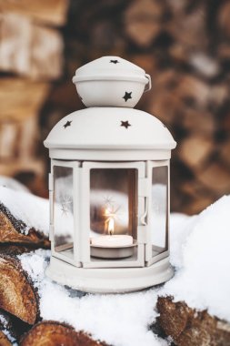 Noel arkaplanı için ahşap kütüklerin önündeki klasik fener.
