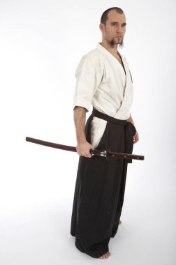Kimono eğitimi almış ciddi bir erkek karate dövüşçüsü beyaz stüdyo arka planında izole edilmiş, dövüş sanatları konsepti. 