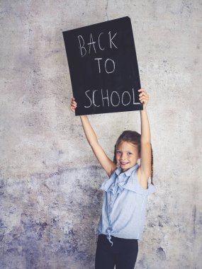 Blackboard kelimelerle okula beton arka plan önünde engel kız öğrenci