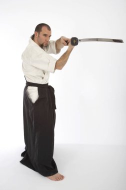 Kimono eğitimi almış ciddi bir erkek karate dövüşçüsü beyaz stüdyo arka planında izole edilmiş, dövüş sanatları konsepti. 