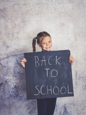 Blackboard kelimelerle okula beton arka plan önünde engel kız öğrenci