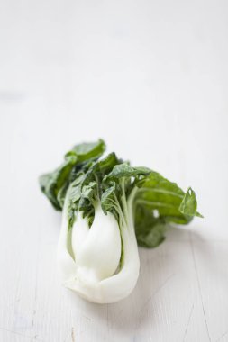 Beyaz ahşap arka planda taze yeşil pakchoi