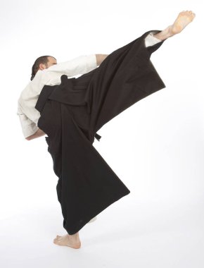 Kimono eğitimi almış ciddi bir erkek karate dövüşçüsü beyaz stüdyo arka planında izole edilmiş, dövüş sanatları konsepti. 