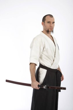 Kimono eğitimi almış ciddi bir erkek karate dövüşçüsü beyaz stüdyo arka planında izole edilmiş, dövüş sanatları konsepti. 