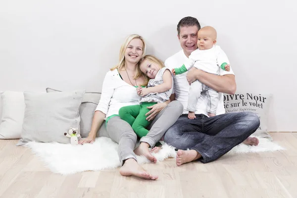 family portrait of beautiful family with two kids on white