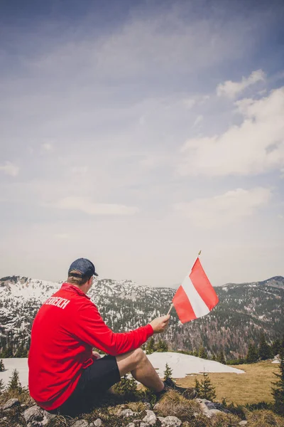 앉아있는 오스트리아 국기를 빨간색 스웨터 등산객 — 스톡 사진