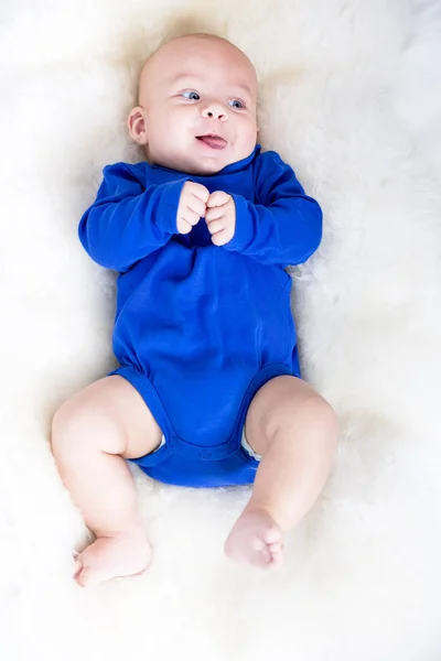 可爱的小婴儿在蓝色 T恤躺在白色的被单 — 图库照片