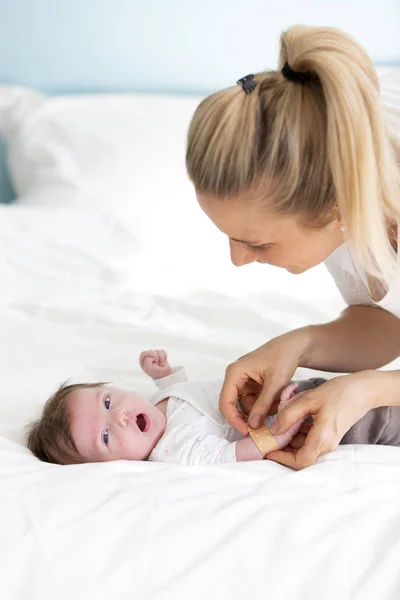 Une Mère Médecin Une Infirmière Pose Plâtre Sur Main Bébé Photos De Stock Libres De Droits