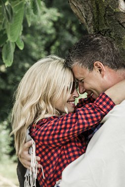 güneşli bir gün bahçede ağaca yakın sarılarak aşk mutlu çift 