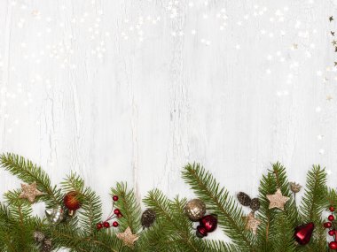 beyaz ahşap arka plan üzerinde baubles ve çam kozalağı ile yeşil noel ağacı dalları 