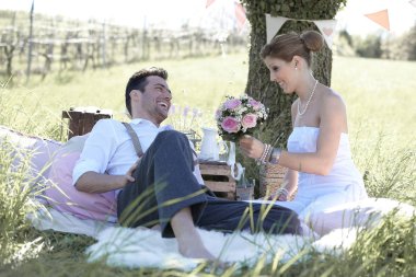 Genç ve güzel gelin ve damat doğada birlikte vakit geçiriyorlar.