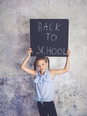 Blackboard kelimelerle okula beton arka plan önünde engel kız öğrenci