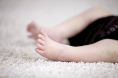 sevimli 3 hafta yeni doğan bebek sarılı bacaklar kahverengi yorgan, tekstil yakın çekim  