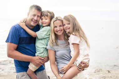 İki çocuklu güzel mutlu bir aile sahilde eğleniyor.