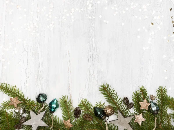 绿色圣诞树树枝与包和松果在白色木制背景 — 图库照片
