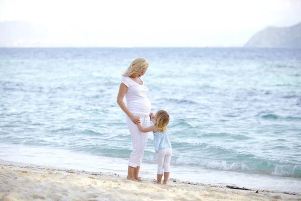 若い妊婦の娘と砂浜で遊んで — ストック写真