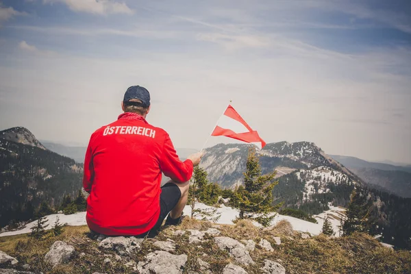 앉아있는 오스트리아 국기를 빨간색 스웨터 등산객 — 스톡 사진