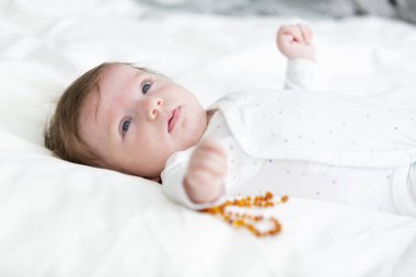 3 aylık güzel, kehribar kolyeli şirin bir bebek.