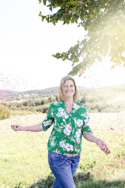 Mutlu memnun kadın yaz güneşli gün çayır konfeti atma