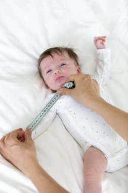 Bebek anne, doktor, kadın tarafından ölçülüyor.