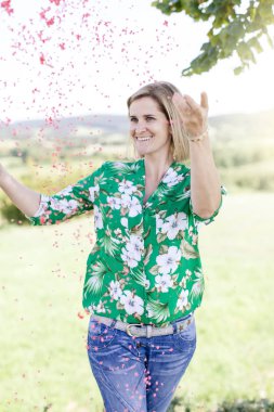 Mutlu memnun kadın yaz güneşli gün çayır konfeti atma