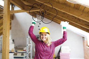 loft baş üzerinde yükseltilmiş kollar ve ampul simgesi ile ayakta güvenlik kask mutlu sarışın kadın oluşturucu, loft genişletmek için fikir kavramı 