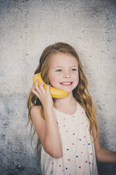 Hübsches Mädchen Telefoniert Mit Banane Auf Grauem Betonwandhintergrund — Stockfoto