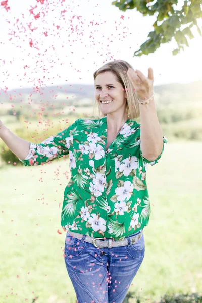 Mutlu memnun kadın yaz güneşli gün çayır konfeti atma