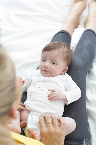 Schöne Junge Mutter Mit Gelbem Hemd Und Baby Bett Kuschelt — Stockfoto