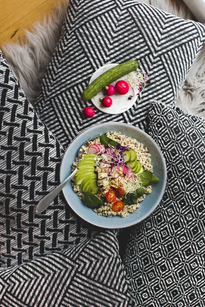 Healthy Quinoa Bulgur bowl with vegetables and chicken and plate with radishes and cucumber