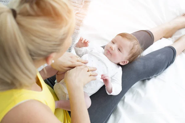 Όμορφη Νεαρή Μητέρα Κίτρινο Πουκάμισο Μωρό Της Στο Κρεβάτι Αγκαλιάζονται — Φωτογραφία Αρχείου