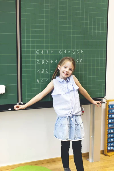 美丽的女孩靠黑板在教室里 — 图库照片
