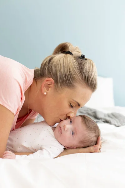 Νέα Όμορφη Και Ξανθιά Μητέρα Ροζ Πουκάμισο Αγκαλιάζει Μωρό Της — Φωτογραφία Αρχείου