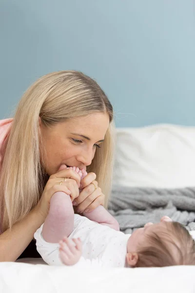 Νέα Όμορφη Και Ξανθιά Μητέρα Ροζ Πουκάμισο Αγκαλιάζει Μωρό Της — Φωτογραφία Αρχείου