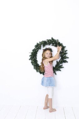 Beyaz arka plan üzerinde izole Noel çelenk ile poz mutlu güzel kız