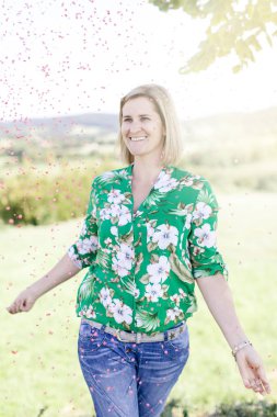 Mutlu memnun kadın yaz güneşli gün çayır konfeti atma