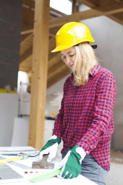 sarışın kadınla sarı kask ve loft dizüstü genişlemesi planlama yeşil eldiven