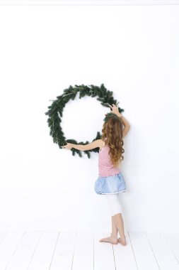 Beyaz arka plan üzerinde izole Noel çelenk ile poz mutlu güzel kız