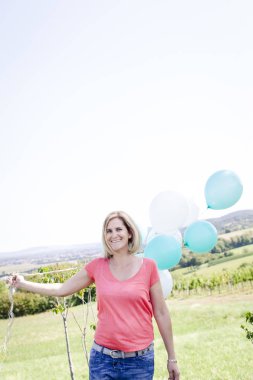 Balon ile mutlu kadın yaz güneşli gün çayır üzerinde eğlenmek 
