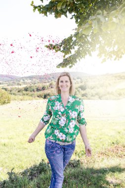 Mutlu memnun kadın yaz güneşli gün çayır konfeti atma