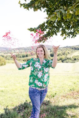 Mutlu memnun kadın yaz güneşli gün çayır konfeti atma