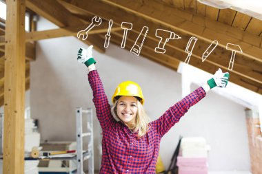 güvenlik kask mutlu sarışın kadın oluşturucu loft baş üzerinde yükseltilmiş kol lar ve araçlar simgesi ile ayakta, fikir kavramı loft genişletmek için 