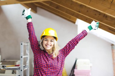 güvenlik kask mutlu sarışın güzel mimar kadın çatı kolları ile ayakta, fikir kavramı loft genişletmek için 