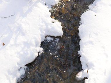 Beyaz kar altında akan soğuk nehir yakın çekim 