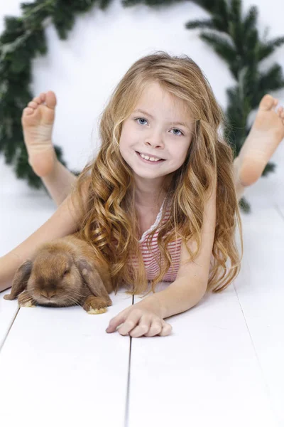 Menina Bonita Feliz Posando Com Coelho Enquanto Deitado Chão Madeira — Fotografia de Stock